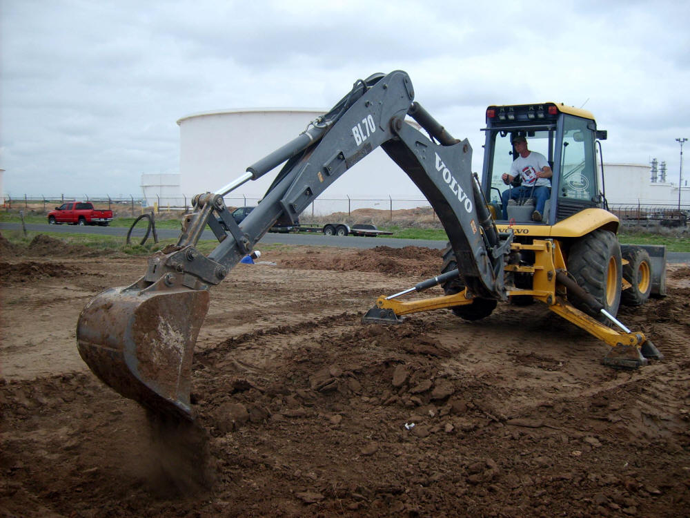 backhoe digging a hole for septic system