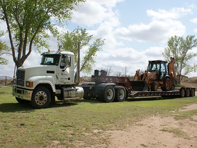 Nex-Gen truck delivering backhoe for septic system project